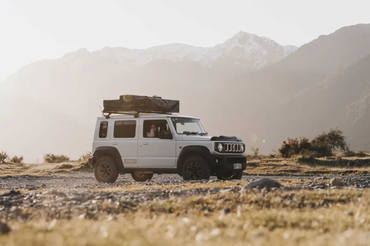 Suzuki Jimny in scenic South Island landscape. – Jimny Rentals.