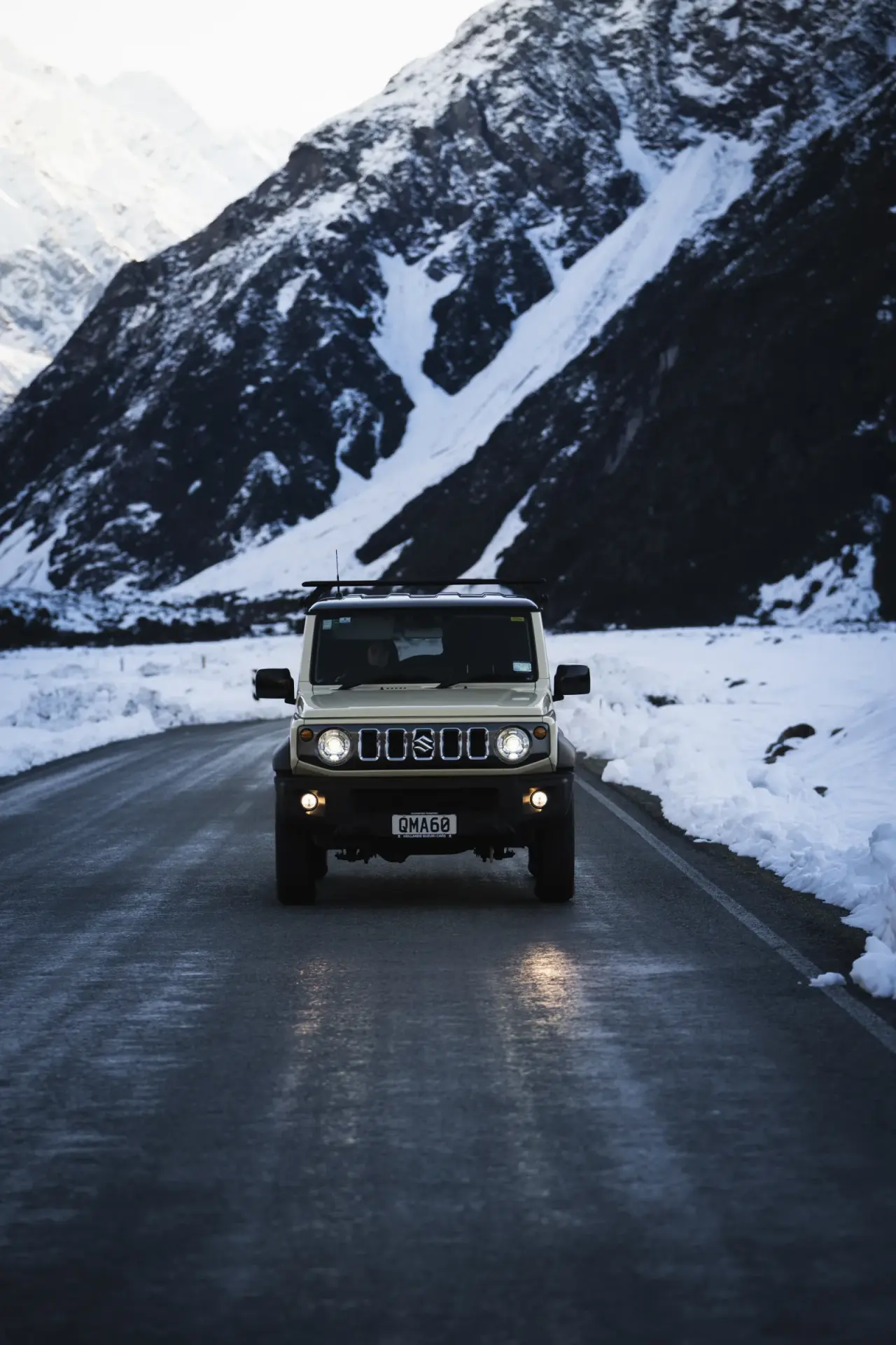 Suzuki Jimny in snowy mountain landscape, winter adventure. – Jimny Rentals.