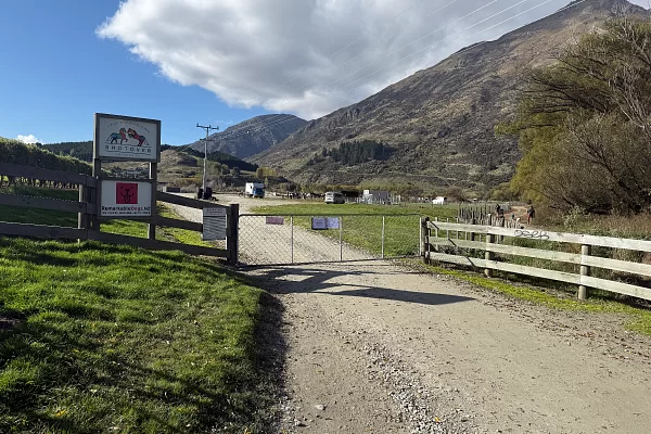 Gravel driveway leading to the Shotover Equestrian gate, with Shotover signage and mountain backdrop — follow this driveway from the left-side parking